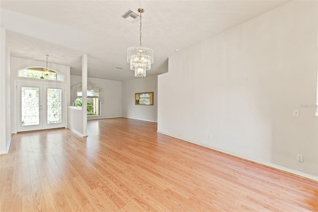 7328 Blue Skies Dr, Spring Hill, FL 34606 - unfurnished living room with a chandelier, light wood-style flooring, and french doors