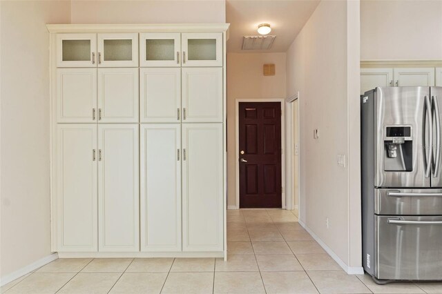 7328 Blue Skies Dr, Spring Hill, FL 34606 - kitchen with stainless steel fridge with ice dispenser, light tile patterned flooring, glass insert cabinets, and cream cabinets