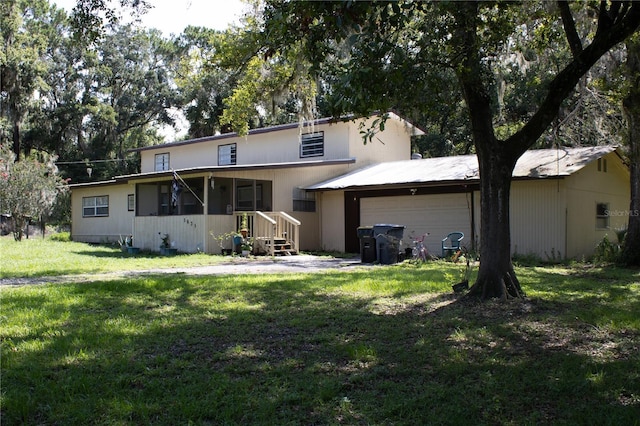 5635 Kimball Rd, Mulberry, FL 33860 - rear view of property featuring a garage and a lawn