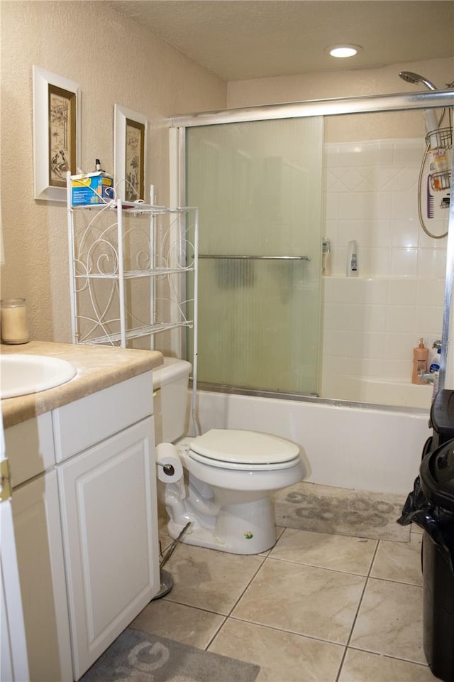 5635 Kimball Rd, Mulberry, FL 33860 - full bath with a textured wall, vanity, bath / shower combo with glass door, and tile patterned flooring