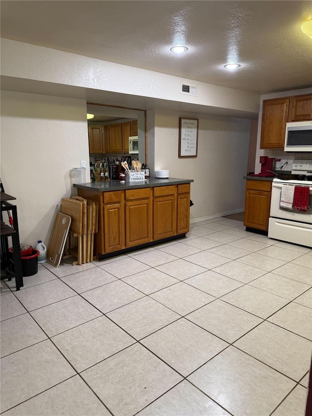5635 Kimball Rd, Mulberry, FL 33860 - kitchen with white appliances, brown cabinetry, a textured ceiling, dark countertops, and backsplash