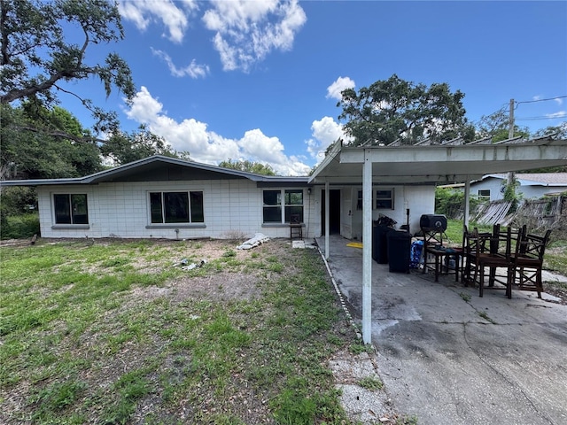 34767 Evergreen Way, Ridge Manor, FL 33523 - rear view of house with concrete block siding and a carport