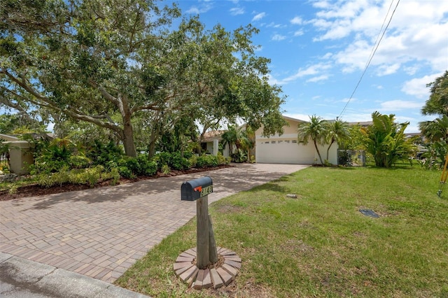 8143 Channel Dr, Port Richey, FL 34668 - view of property hidden behind natural elements with decorative driveway, a front lawn, an attached garage, and stucco siding