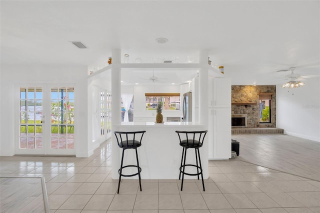 8143 Channel Dr, Port Richey, FL 34668 - kitchen featuring a ceiling fan, open floor plan, light tile patterned floors, and white cabinets