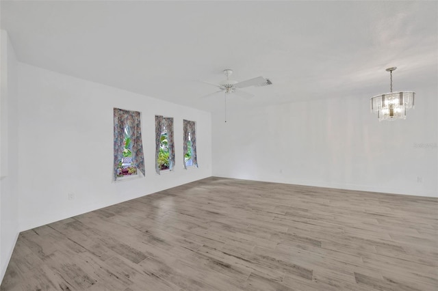 8143 Channel Dr, Port Richey, FL 34668 - unfurnished room with wood finished floors, a chandelier, and a ceiling fan