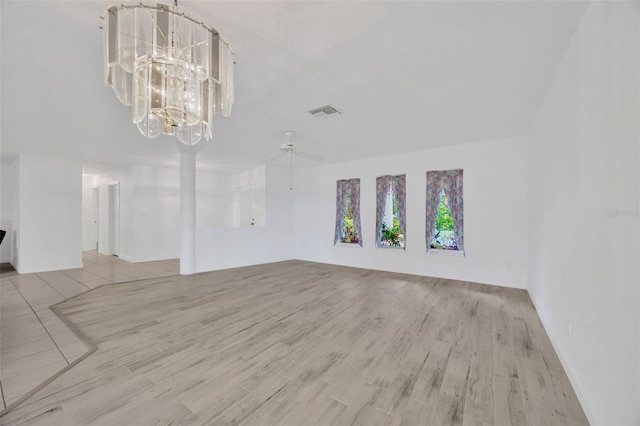 8143 Channel Dr, Port Richey, FL 34668 - unfurnished living room featuring wood finished floors, a ceiling fan, and a chandelier