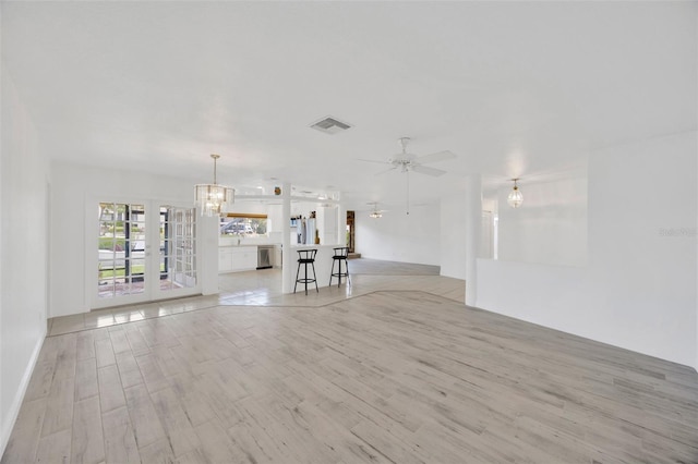 8143 Channel Dr, Port Richey, FL 34668 - unfurnished living room featuring a chandelier, ceiling fan, and light wood finished floors