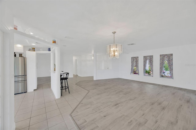 8143 Channel Dr, Port Richey, FL 34668 - unfurnished living room with a chandelier and light tile patterned floors