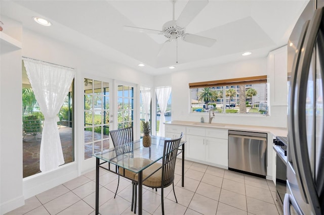 8143 Channel Dr, Port Richey, FL 34668 - dining space with light tile patterned floors, ceiling fan, recessed lighting, and a tray ceiling