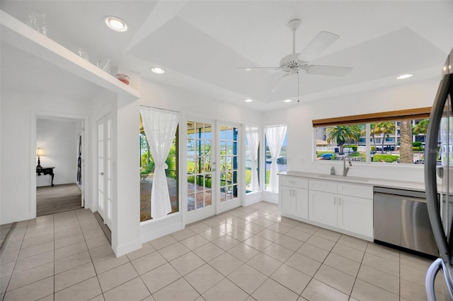 8143 Channel Dr, Port Richey, FL 34668 - kitchen featuring dishwasher, french doors, light tile patterned floors, ceiling fan, and white cabinetry