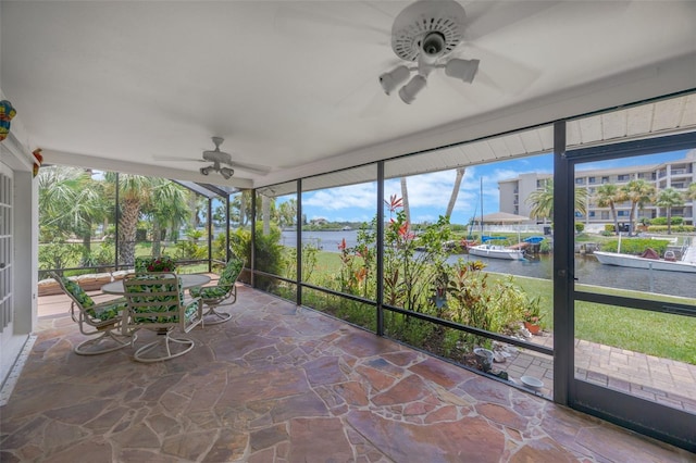 8143 Channel Dr, Port Richey, FL 34668 - sunroom featuring a ceiling fan, a water view, and outdoor dining area