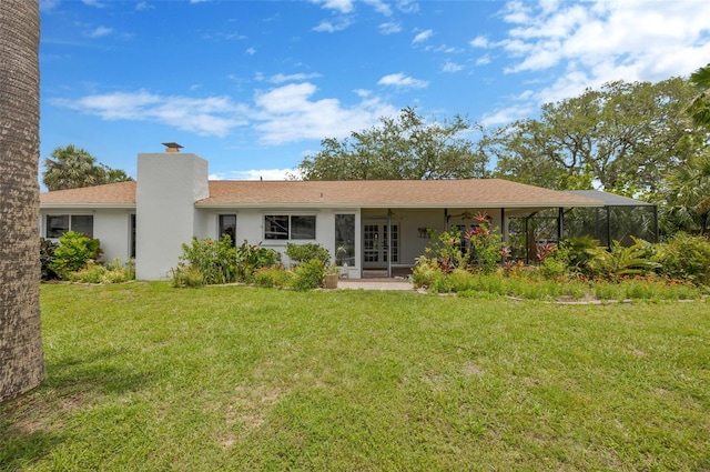 8143 Channel Dr, Port Richey, FL 34668 - back of property featuring a yard, french doors, a chimney, a ceiling fan, and stucco siding