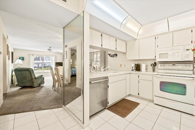 12141 Spartan Way Unit 102, Hudson, FL 34667 - kitchen with white appliances, light tile patterned flooring, open floor plan, light countertops, and light carpet
