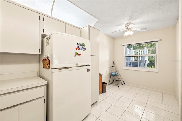 12141 Spartan Way Unit 102, Hudson, FL 34667 - kitchen featuring freestanding refrigerator, ceiling fan, light countertops, a textured ceiling, and light tile patterned floors