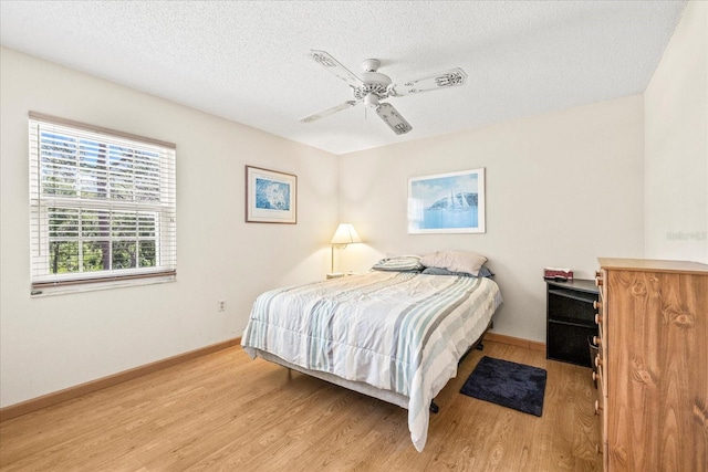 12141 Spartan Way Unit 102, Hudson, FL 34667 - bedroom with light wood-style flooring, a textured ceiling, and ceiling fan