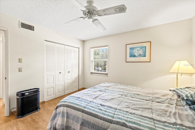 12141 Spartan Way Unit 102, Hudson, FL 34667 - bedroom featuring wood finished floors, a closet, a textured ceiling, and ceiling fan