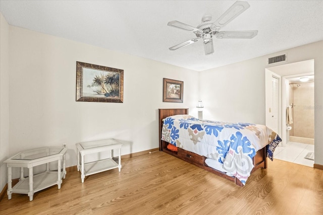 12141 Spartan Way Unit 102, Hudson, FL 34667 - bedroom with light wood-style flooring, ceiling fan, and ensuite bath