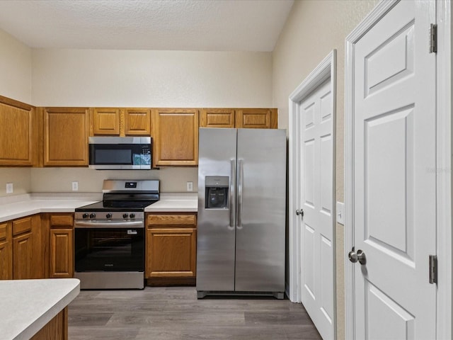 5048 Teather St, Spring Hill, FL 34608 - kitchen with stainless steel appliances, brown cabinetry, and light countertops