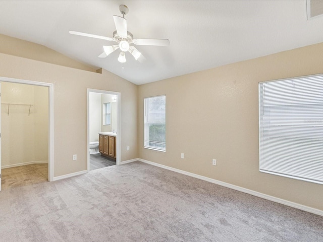 5048 Teather St, Spring Hill, FL 34608 - unfurnished bedroom featuring vaulted ceiling, a spacious closet, carpet flooring, connected bathroom, and a closet