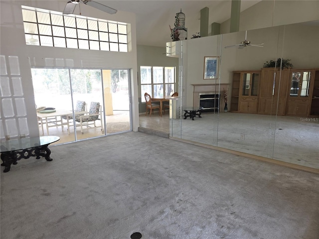 9168 Southern Comfort Ct, Weeki Wachee, FL 34613 - unfurnished living room with a ceiling fan, high vaulted ceiling, carpet floors, and a fireplace
