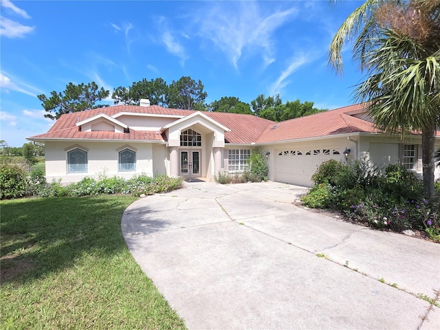 9168 Southern Comfort Ct, Weeki Wachee, FL 34613 - view of front facade with french doors, stucco siding, a front yard, and a tiled roof