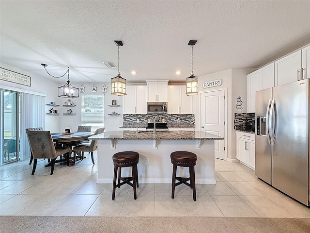 8855 Prairie Creek Dr, New Port Richey, FL 34655 - kitchen with stainless steel appliances, decorative backsplash, a kitchen bar, dark stone counters, and recessed lighting