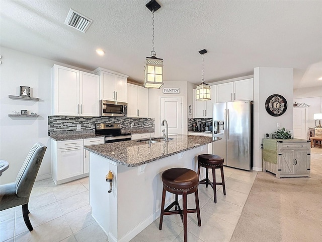8855 Prairie Creek Dr, New Port Richey, FL 34655 - kitchen with stainless steel appliances, light tile patterned flooring, tasteful backsplash, dark stone countertops, and recessed lighting
