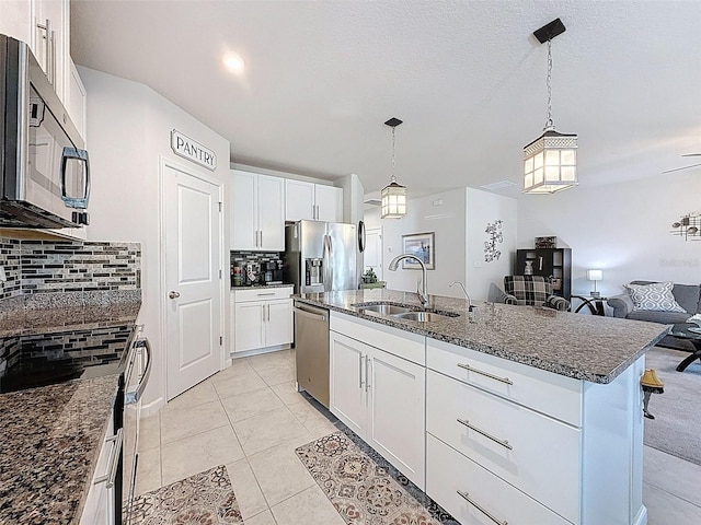 8855 Prairie Creek Dr, New Port Richey, FL 34655 - kitchen with stainless steel appliances, backsplash, dark stone countertops, and white cabinets