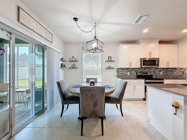 8855 Prairie Creek Dr, New Port Richey, FL 34655 - dining room featuring light tile patterned floors, a chandelier, a textured ceiling, and recessed lighting