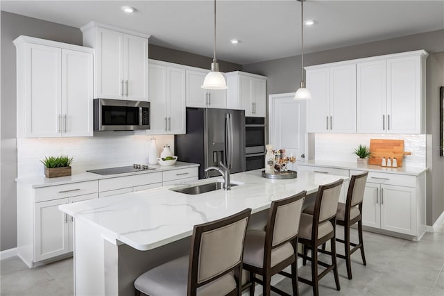 10816 SW 72nd Cir, Ocala, FL 34476 - kitchen with stainless steel appliances, white cabinetry, backsplash, a kitchen bar, and light stone counters