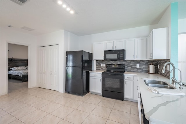 12119 Barnsley Reserve Pl, Gibsonton, FL 33534 - kitchen featuring black appliances, decorative backsplash, white cabinetry, and light stone countertops