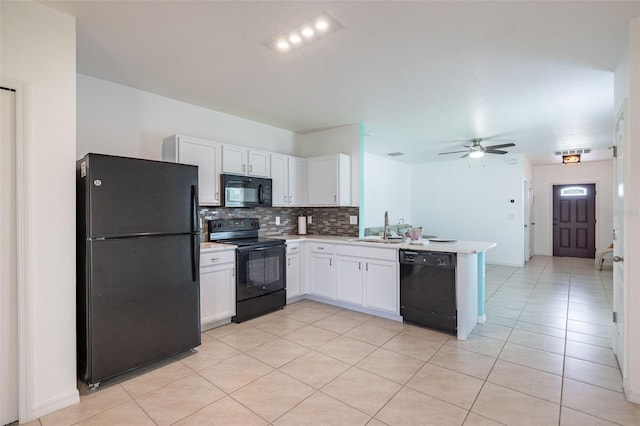 12119 Barnsley Reserve Pl, Gibsonton, FL 33534 - kitchen with black appliances, a peninsula, backsplash, white cabinets, and light countertops
