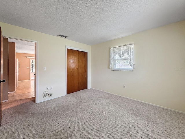 11094 Auburndale St, Spring Hill, FL 34609 - unfurnished bedroom featuring a closet, carpet floors, a textured ceiling, and freestanding refrigerator