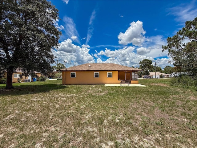 11094 Auburndale St, Spring Hill, FL 34609 - back of house featuring a patio area, a lawn, a sunroom, and stucco siding