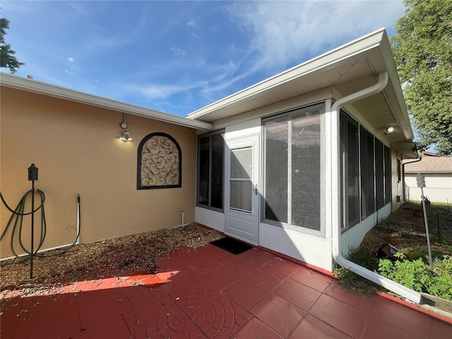 10458 Clingman St, Spring Hill, FL 34608 - view of home's exterior with a sunroom, a patio, and stucco siding