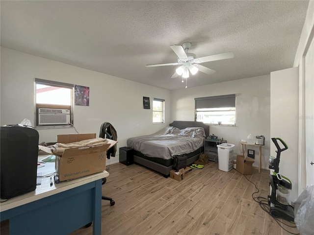 10458 Clingman St, Spring Hill, FL 34608 - bedroom featuring light wood-type flooring, cooling unit, a textured ceiling, and a ceiling fan