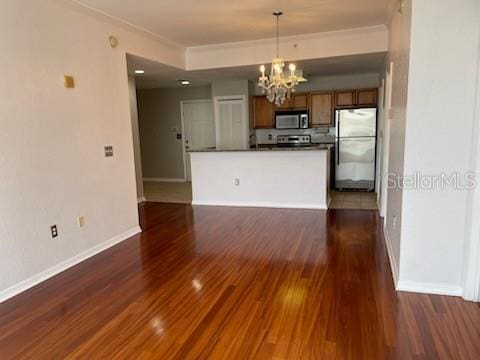 700 S Harbour Island Blvd Unit 407, Tampa, FL 33602 - kitchen featuring freestanding refrigerator, stainless steel microwave, dark countertops, a chandelier, and wood finished floors