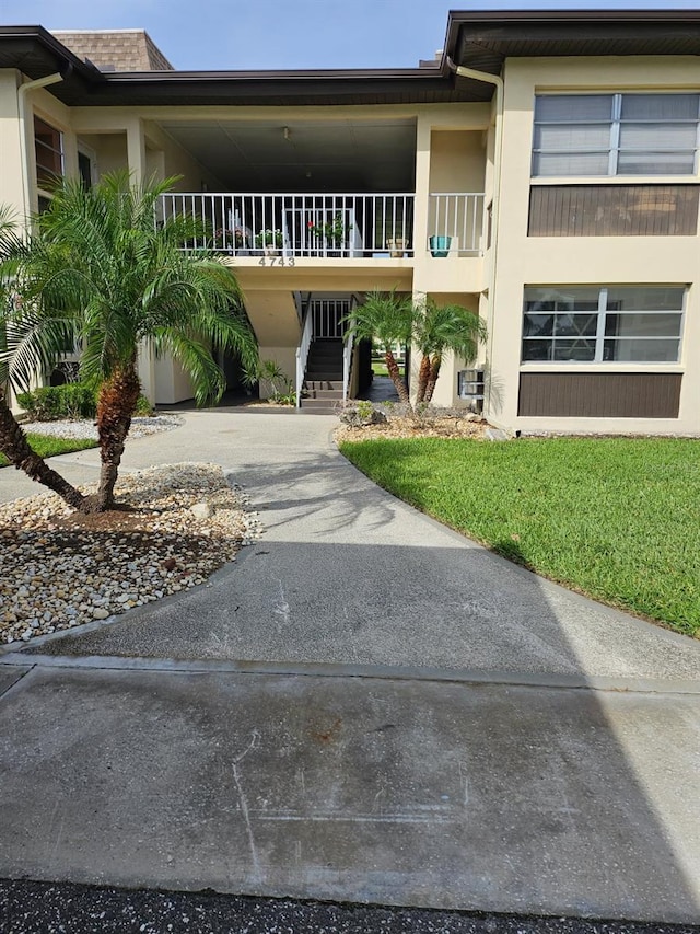 4743 Jasper Dr Unit 107, New Port Richey, FL 34652 - view of building exterior with stairway, driveway, and a carport