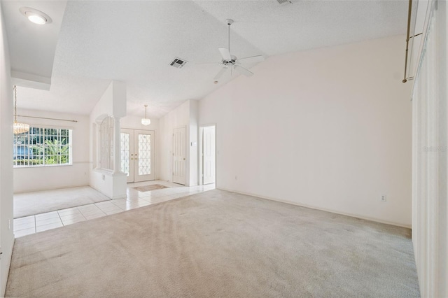 10394 Ireland St, Spring Hill, FL 34608 - carpeted empty room featuring tile patterned floors, vaulted ceiling, french doors, ceiling fan, and a chandelier