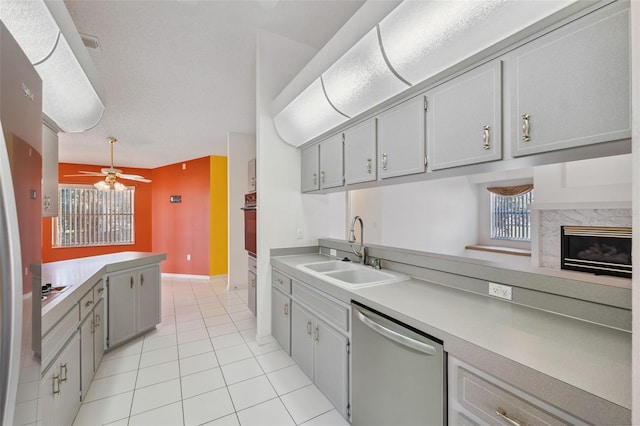 10394 Ireland St, Spring Hill, FL 34608 - kitchen with stainless steel appliances, a ceiling fan, light countertops, light tile patterned floors, and a high end fireplace