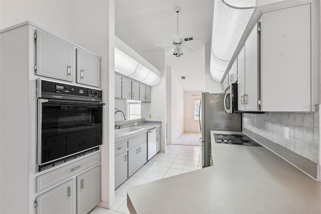 10394 Ireland St, Spring Hill, FL 34608 - kitchen with appliances with stainless steel finishes, a ceiling fan, light tile patterned floors, light countertops, and tasteful backsplash