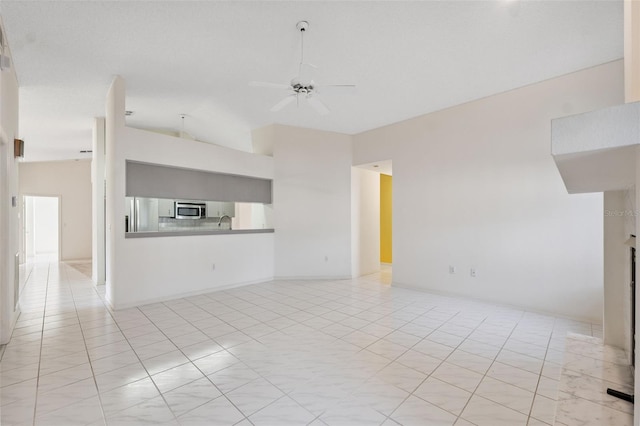 10394 Ireland St, Spring Hill, FL 34608 - unfurnished living room featuring a ceiling fan, vaulted ceiling, and light tile patterned floors