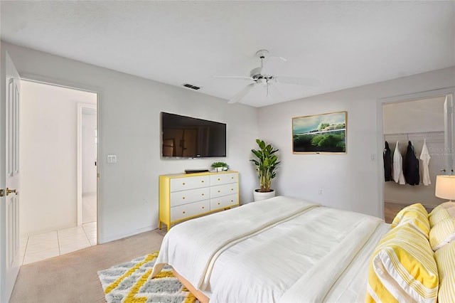 10394 Ireland St, Spring Hill, FL 34608 - bedroom with light carpet, ceiling fan, light tile patterned floors, and a spacious closet