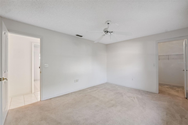 10394 Ireland St, Spring Hill, FL 34608 - unfurnished bedroom with carpet, a walk in closet, ceiling fan, and a closet