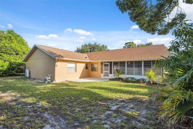 10394 Ireland St, Spring Hill, FL 34608 - rear view of property featuring stucco siding, a sunroom, a patio, and a lawn