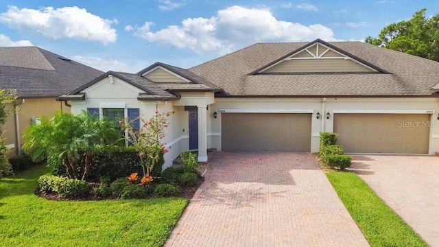 16874 Balance Cv, Land O Lakes, FL 34638 - view of front of home with stucco siding, decorative driveway, a shingled roof, and an attached garage