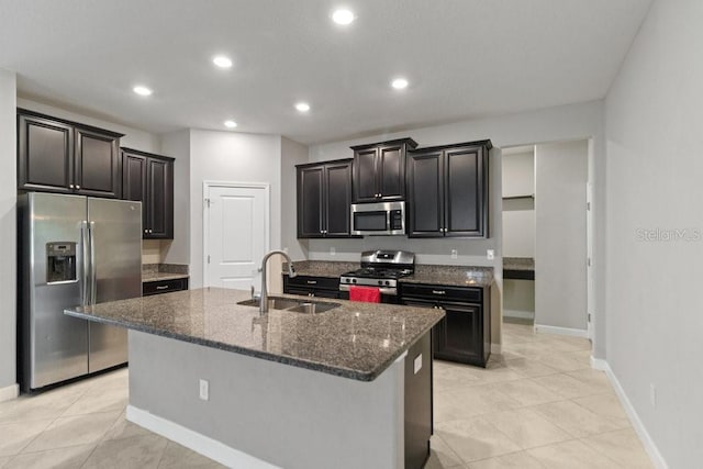 16874 Balance Cv, Land O Lakes, FL 34638 - kitchen with appliances with stainless steel finishes, recessed lighting, dark stone countertops, an island with sink, and light tile patterned floors