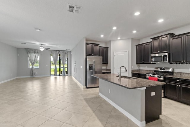 16874 Balance Cv, Land O Lakes, FL 34638 - kitchen featuring appliances with stainless steel finishes, an island with sink, light tile patterned floors, recessed lighting, and dark stone counters