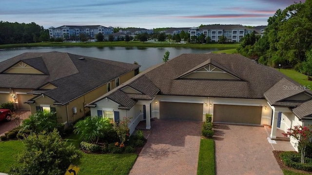 16874 Balance Cv, Land O Lakes, FL 34638 - traditional-style house with a garage, decorative driveway, stucco siding, a water view, and a residential view