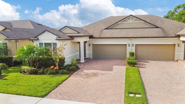 16874 Balance Cv, Land O Lakes, FL 34638 - view of front of house with stucco siding, decorative driveway, roof with shingles, and an attached garage